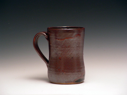 brown stoneware mug sitting on grey surface