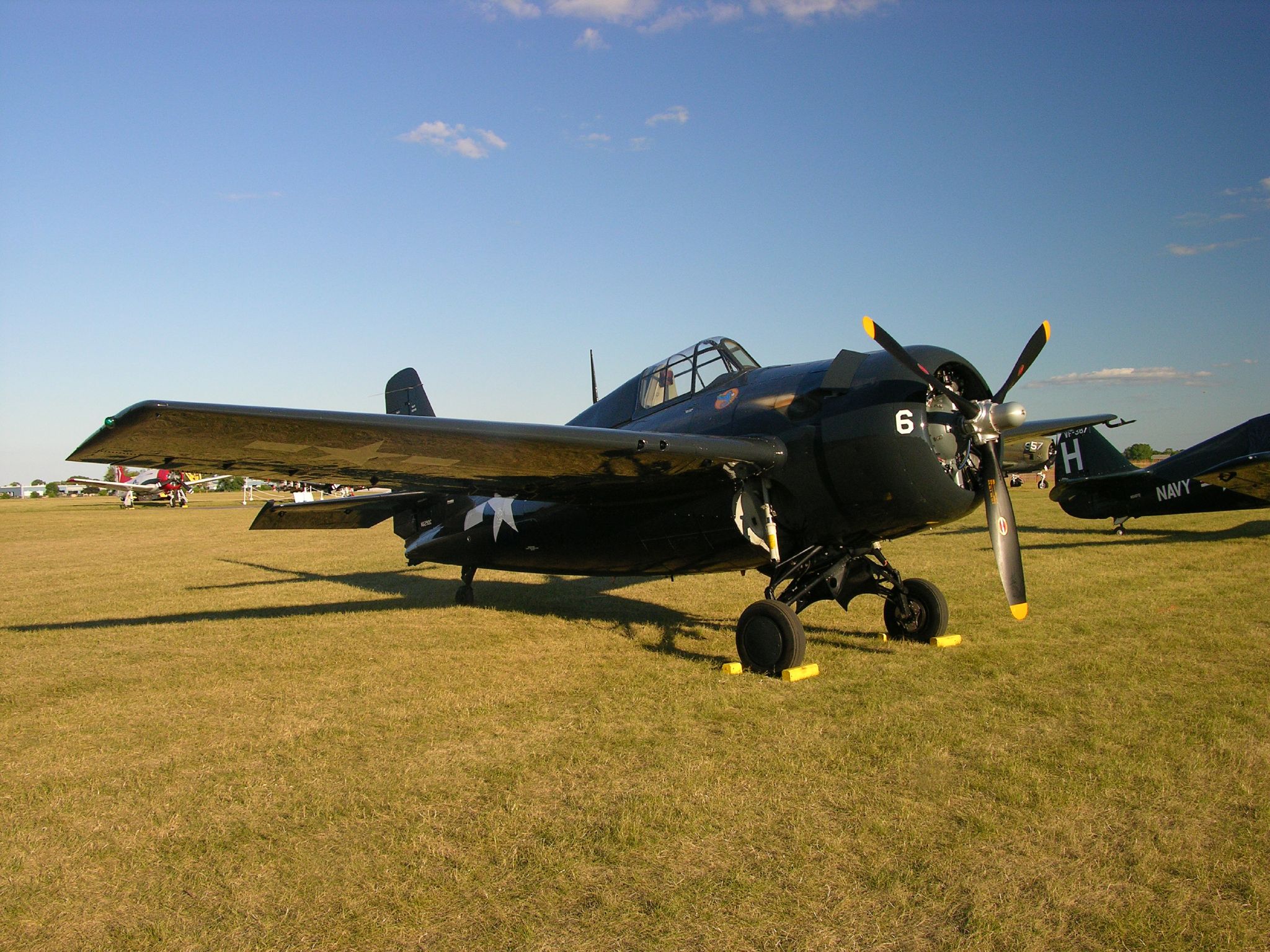 the small plane is parked on the grassy field