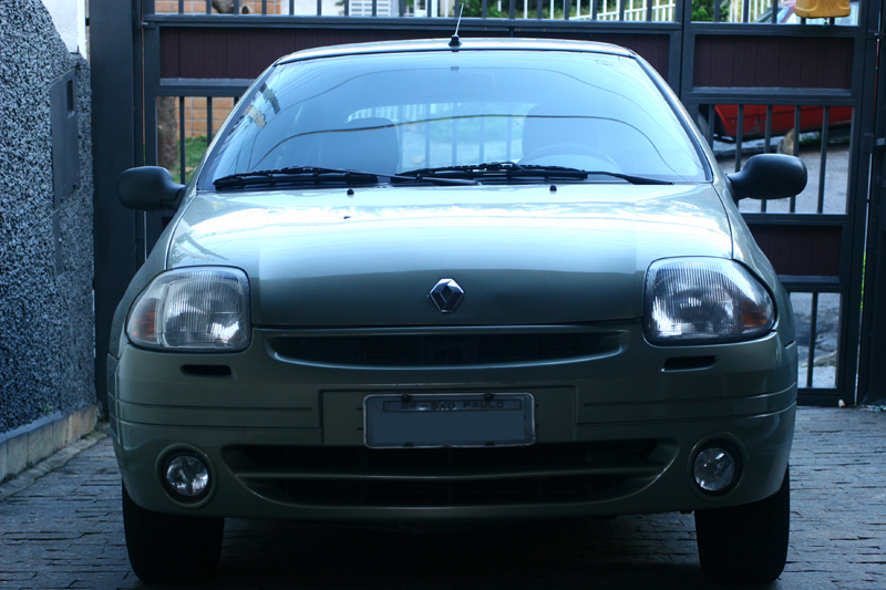 the small car is parked in front of the gate