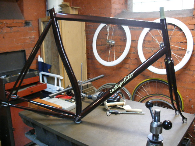 a bike frame sits on a workbench