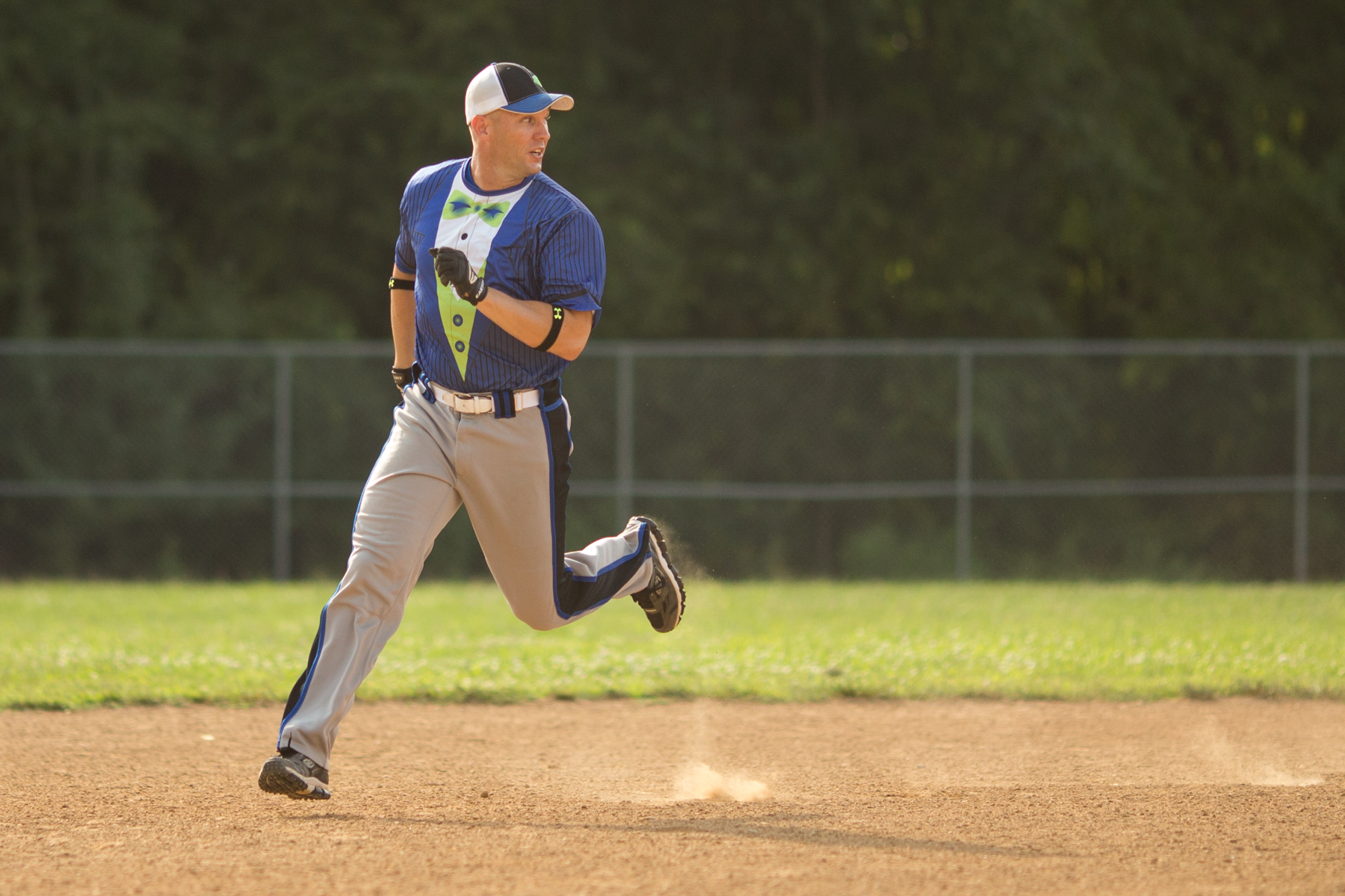 a man runs on a baseball field with a glove in hand