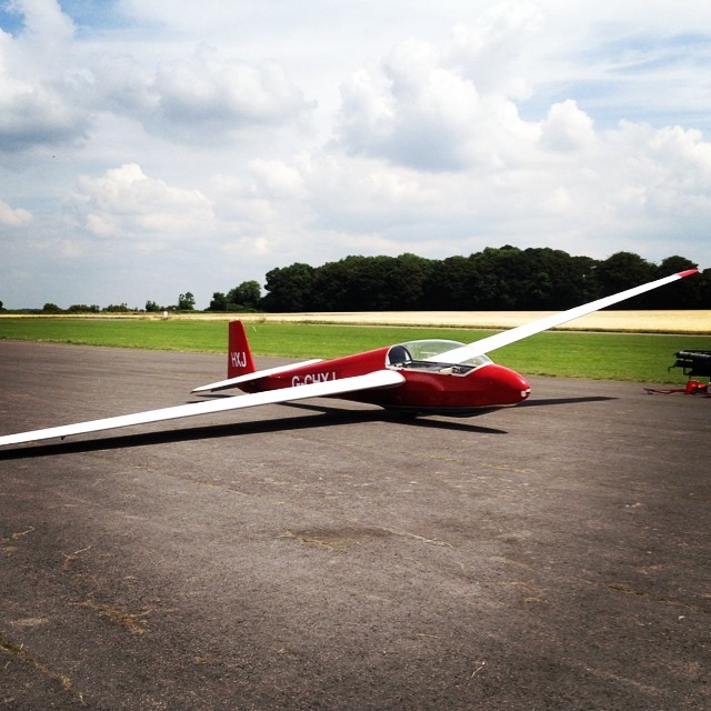 a red airplane sitting on top of an airport runway