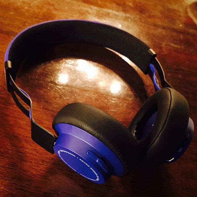 a pair of blue headphones sitting on a wooden table