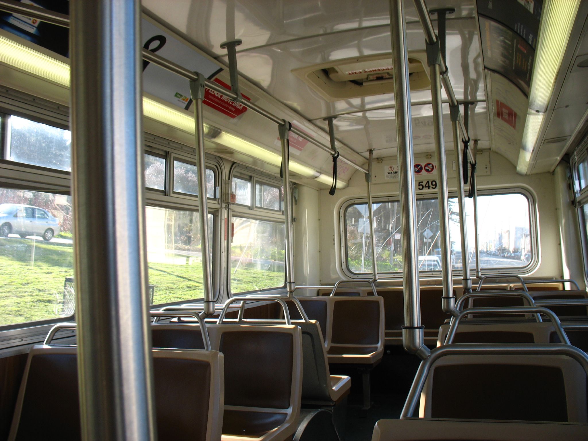 an empty commuter bus has many seats and windows