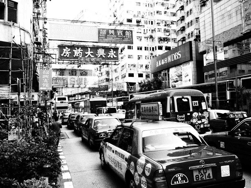 a city street with cars, buses and other vehicles