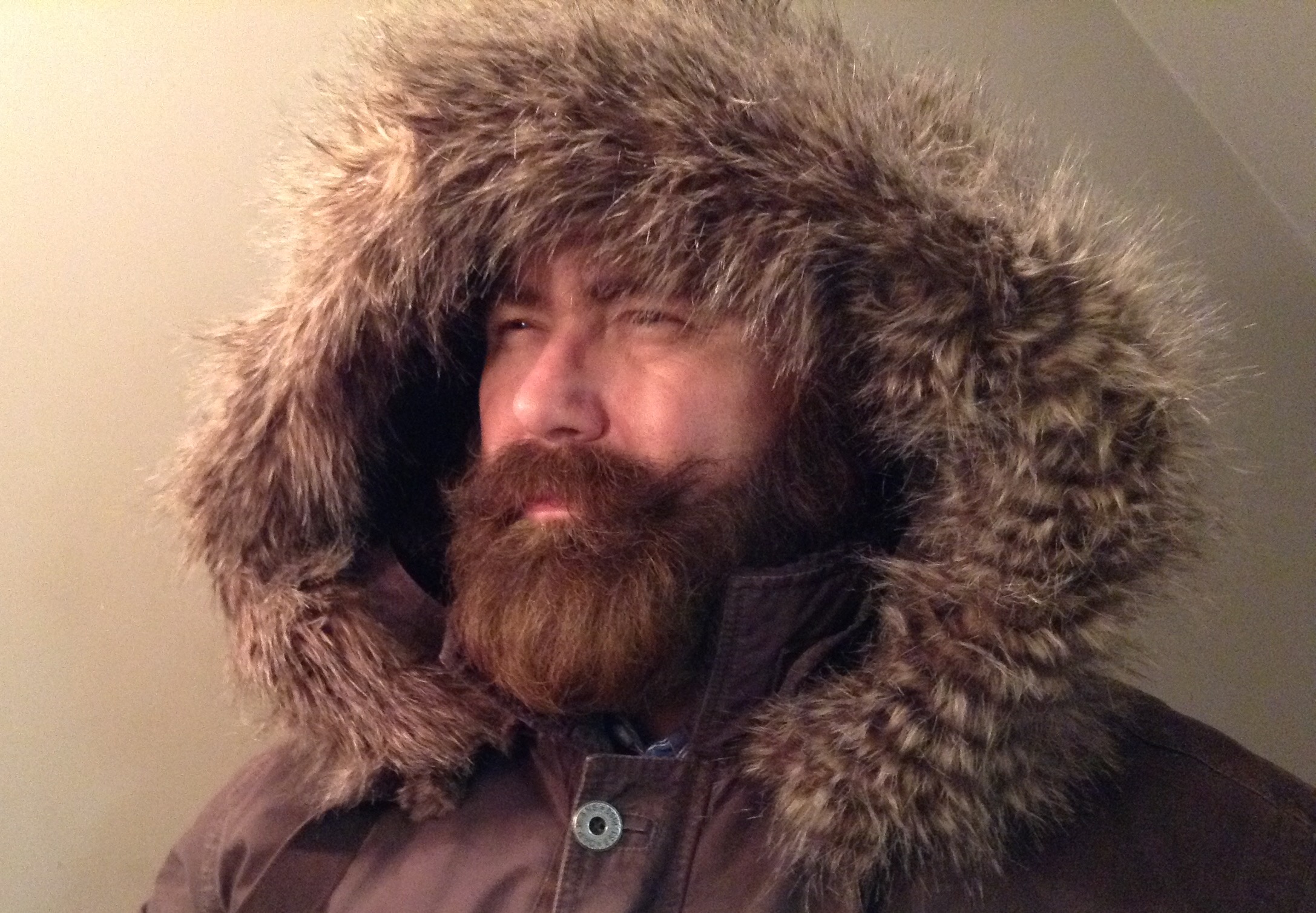 a bearded man with fur on his hood