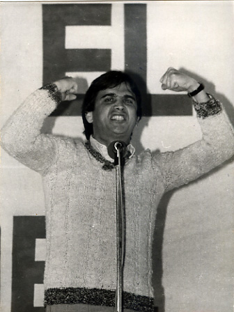 a man holds his fist up while standing at a podium