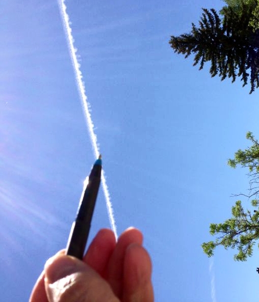 the hand of someone writing a line in the sky