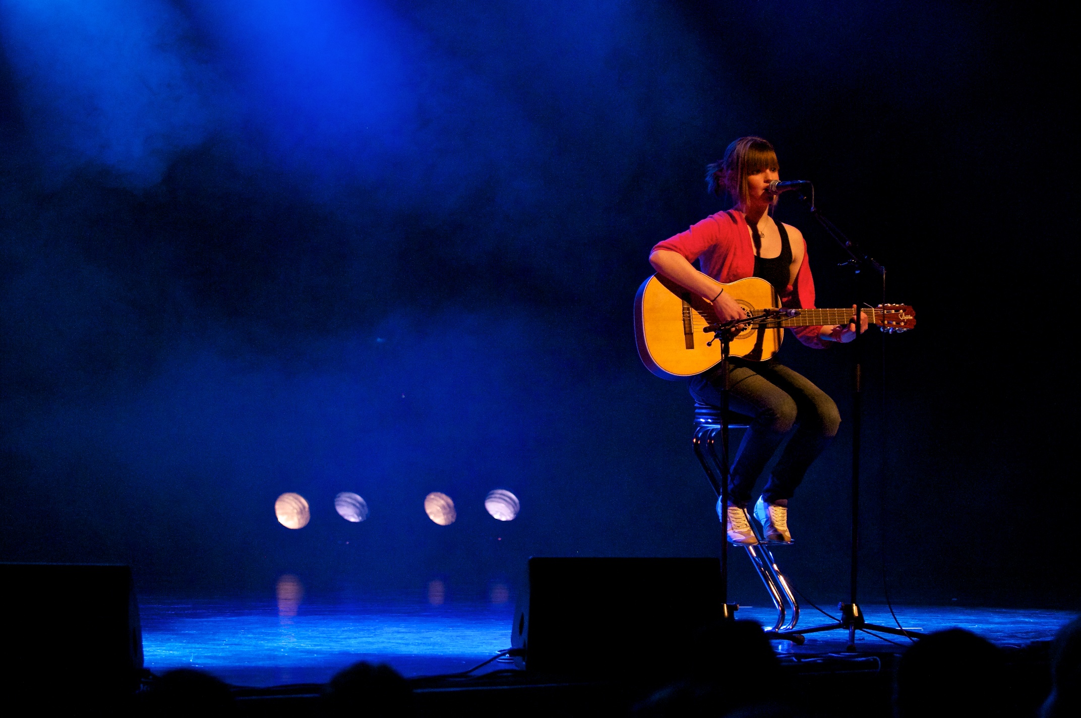 a man holding a guitar on a stage