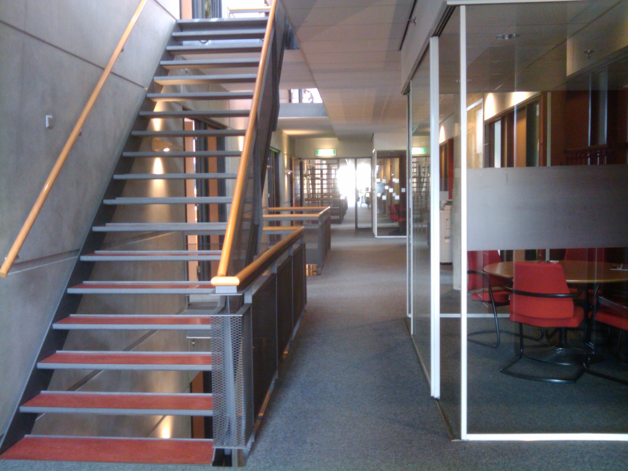 the stairs to the first floor are lined with red chairs
