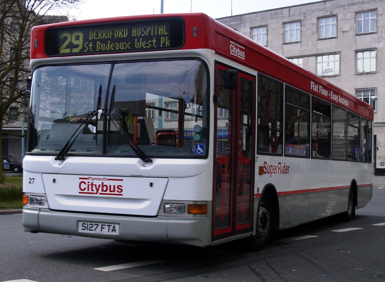 a white and red bus traveling down a city street