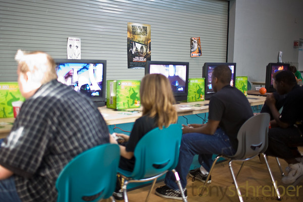 people playing video games in the middle of a game room