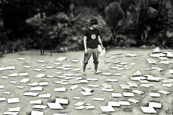 a man is walking among large papers on the ground