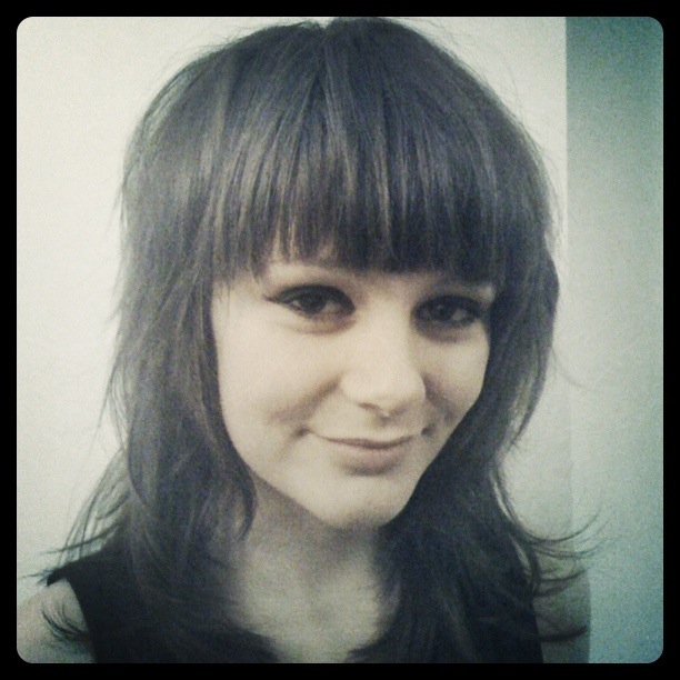 a woman has long bangs and has a smile