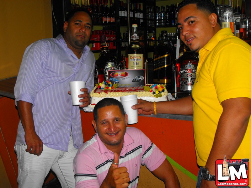 three men in front of a birthday cake