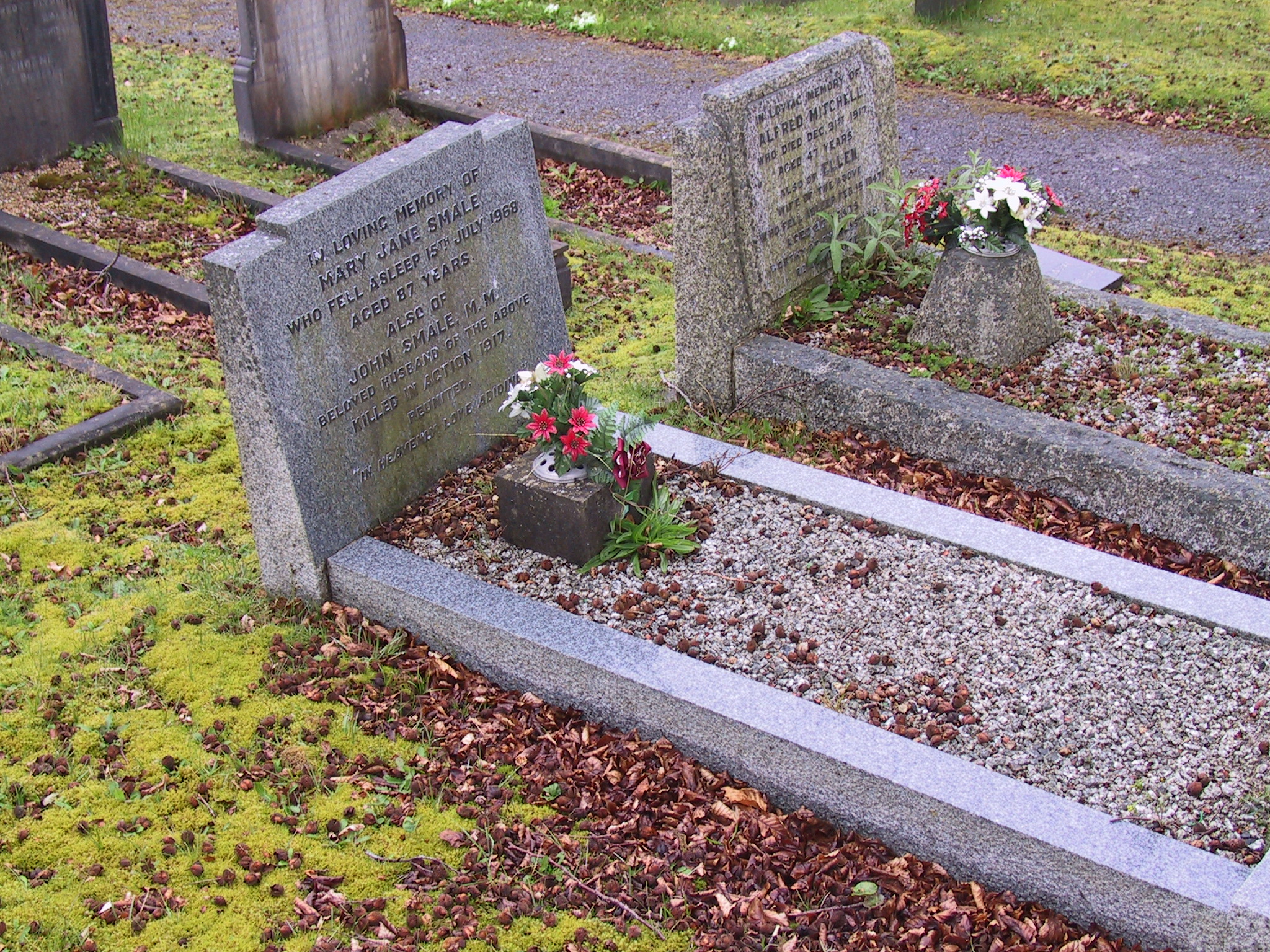 a few cement headstones sitting on the grass