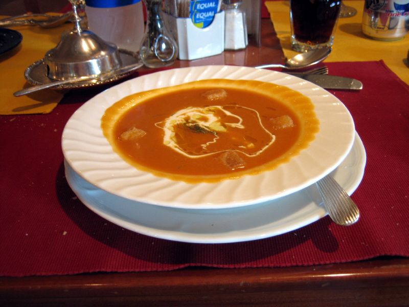 a white plate topped with a soup filled with meat