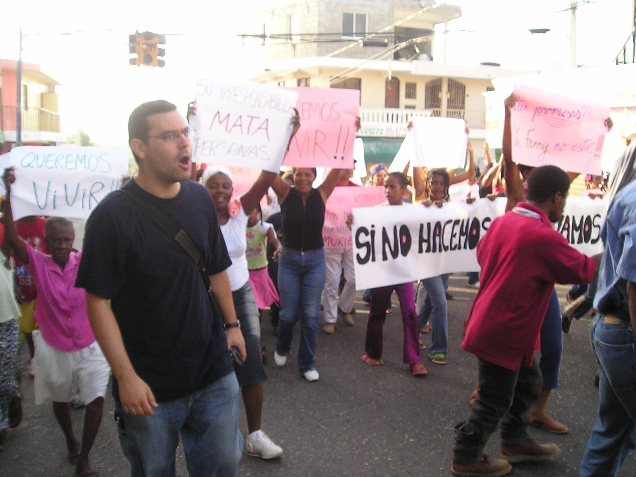 a crowd of people on a street holding up signs