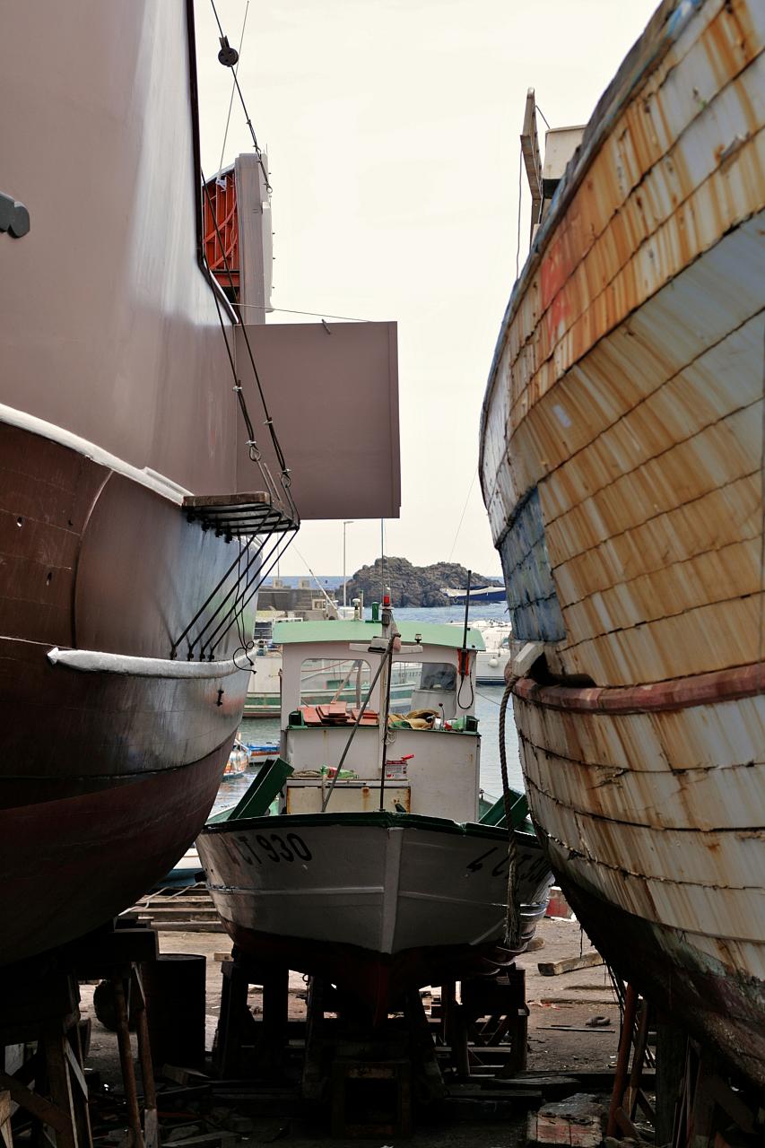three boats sitting on dry land next to each other