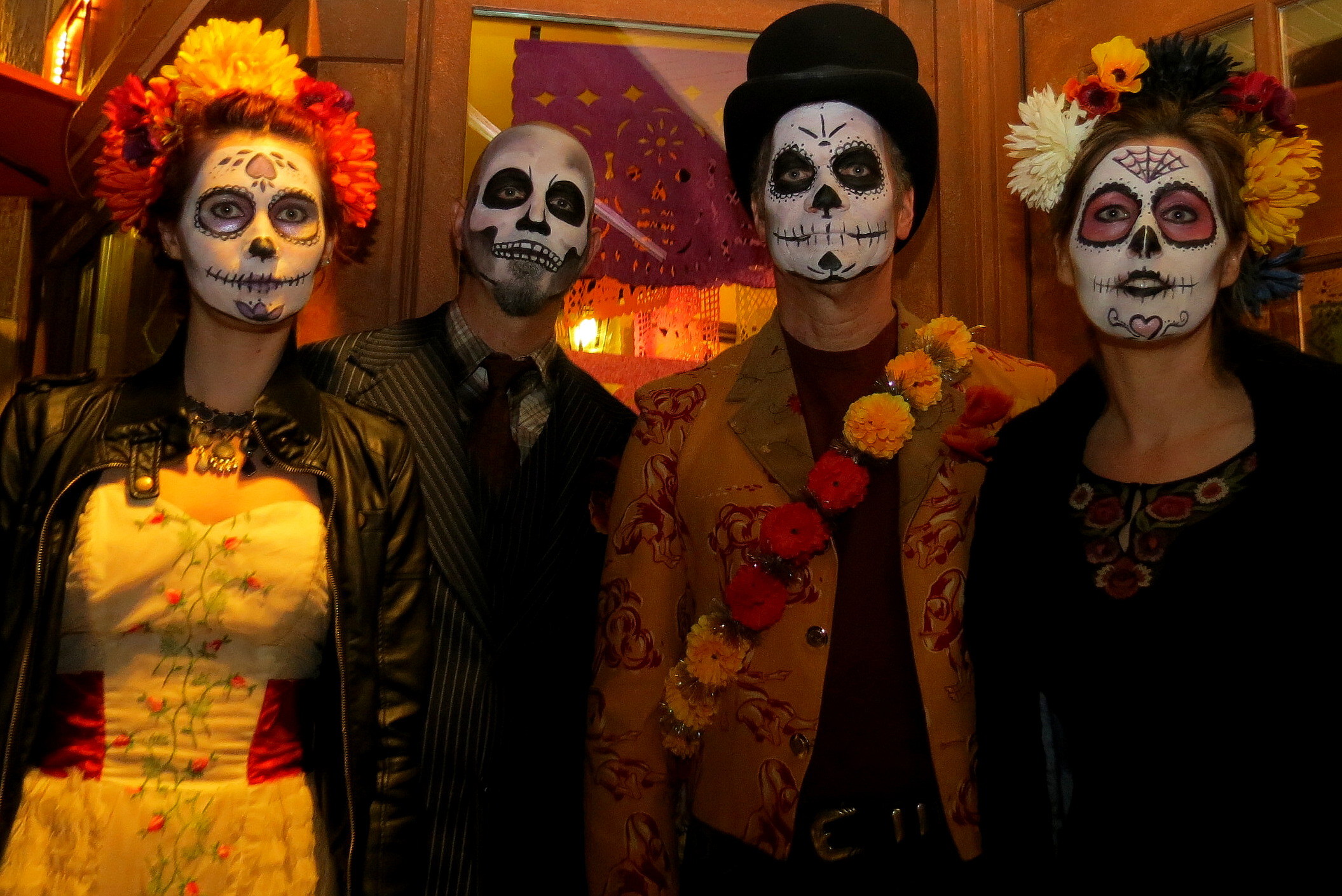 three people wearing halloween face makeup at a party