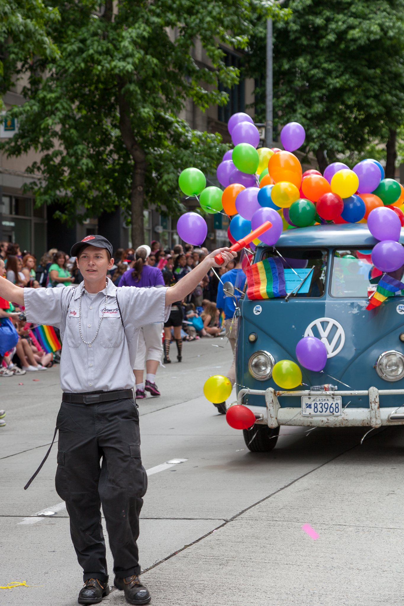 a man is standing next to a vw bus holding balloons