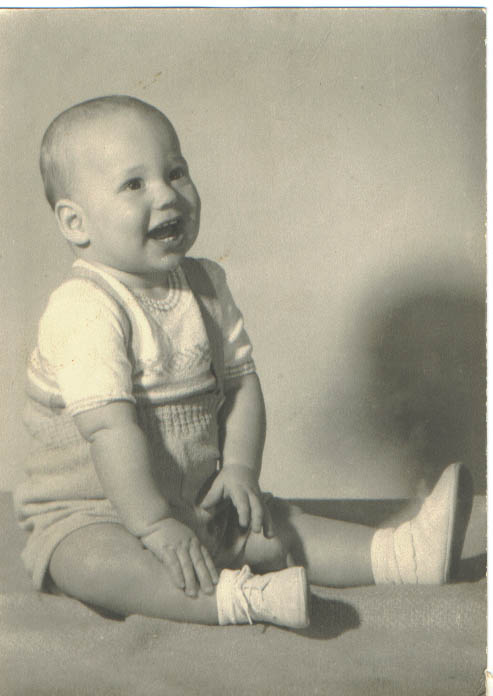 a baby in overalls with a smile on it