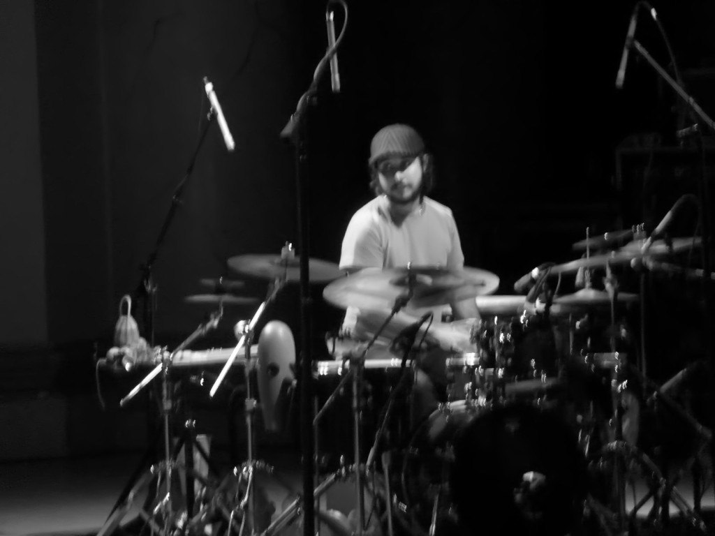 this is a drummer playing drums in front of mic lights