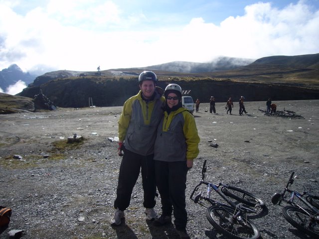 two people are standing in front of a mountain