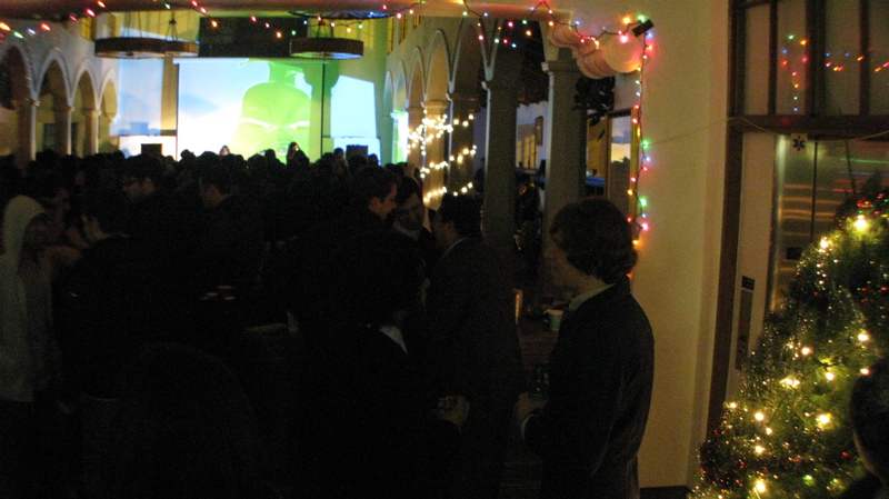 several people are standing around the lobby of a building for a christmas party