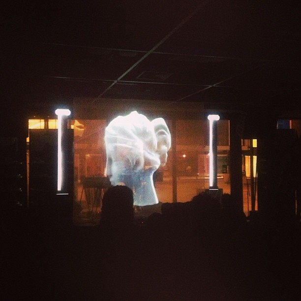 a crowd in front of a huge screen with an image of an elephant on it