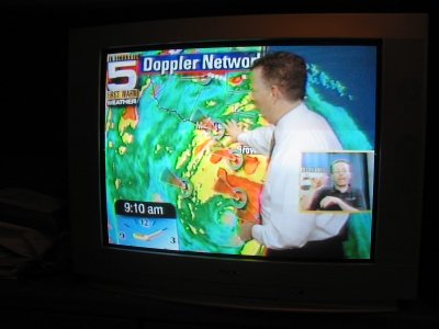 a news anchors with his picture on the television screen