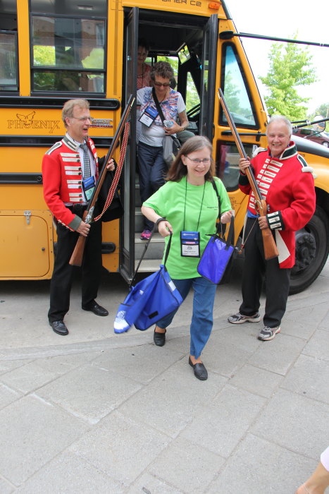 a group of children that are outside by a bus