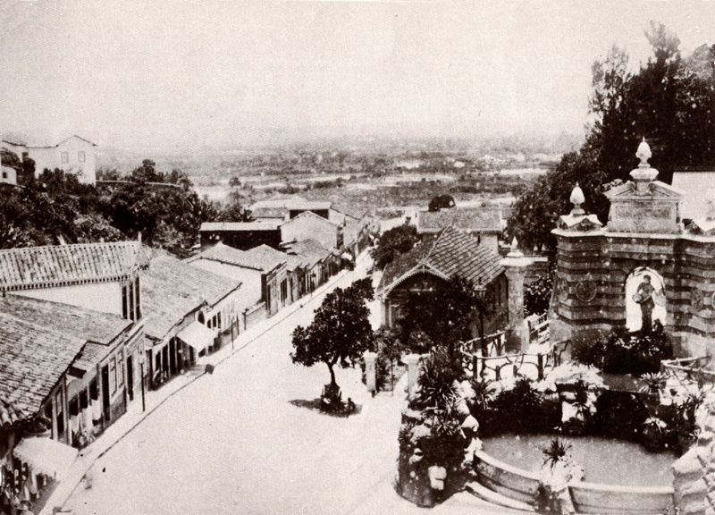 an old pograph looking down at a town with a small gate on top