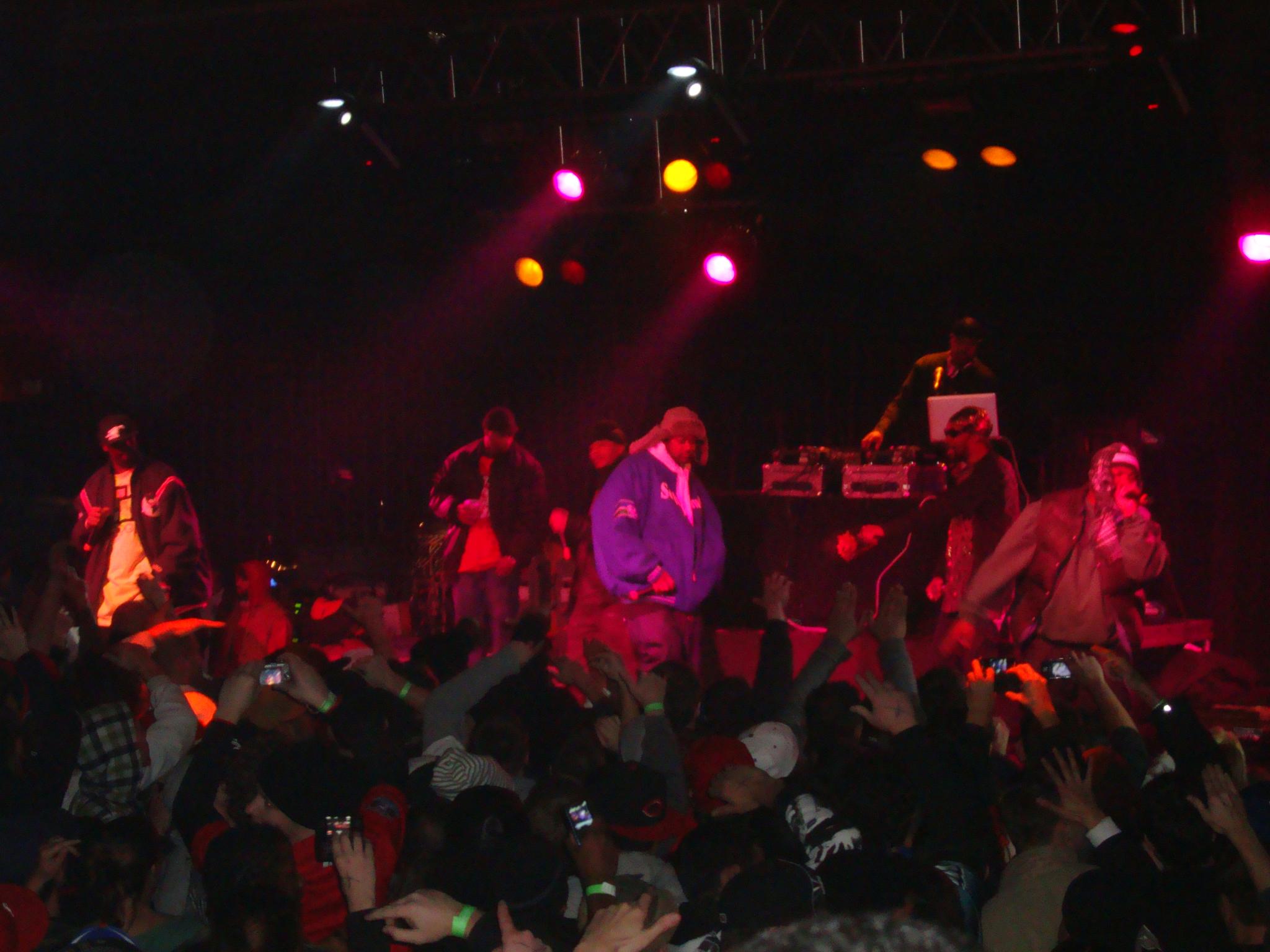 a concert scene with people standing in the middle on stage