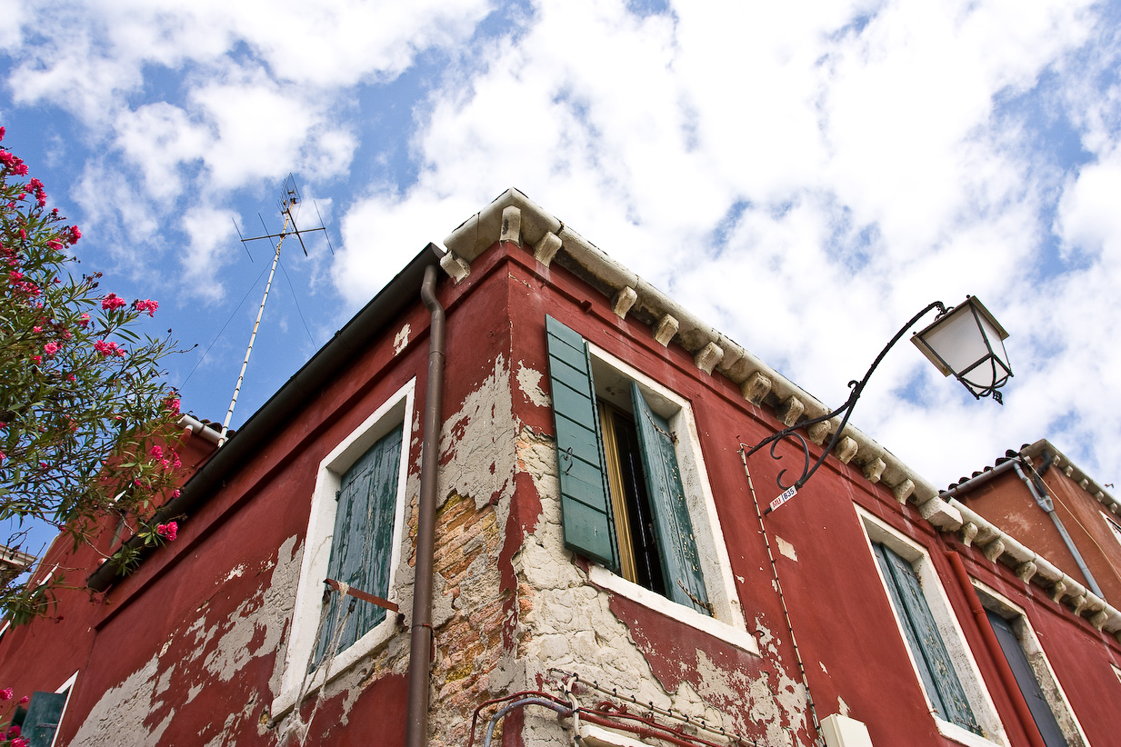 a stop light sitting next to a very old red building