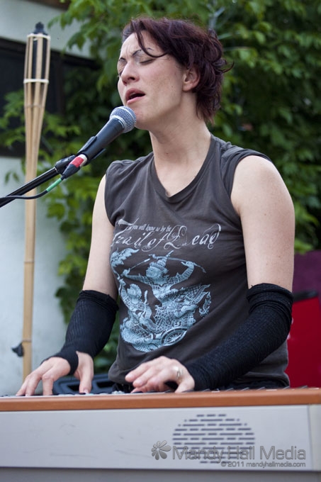 a woman is wearing a sleeveless t - shirt while speaking