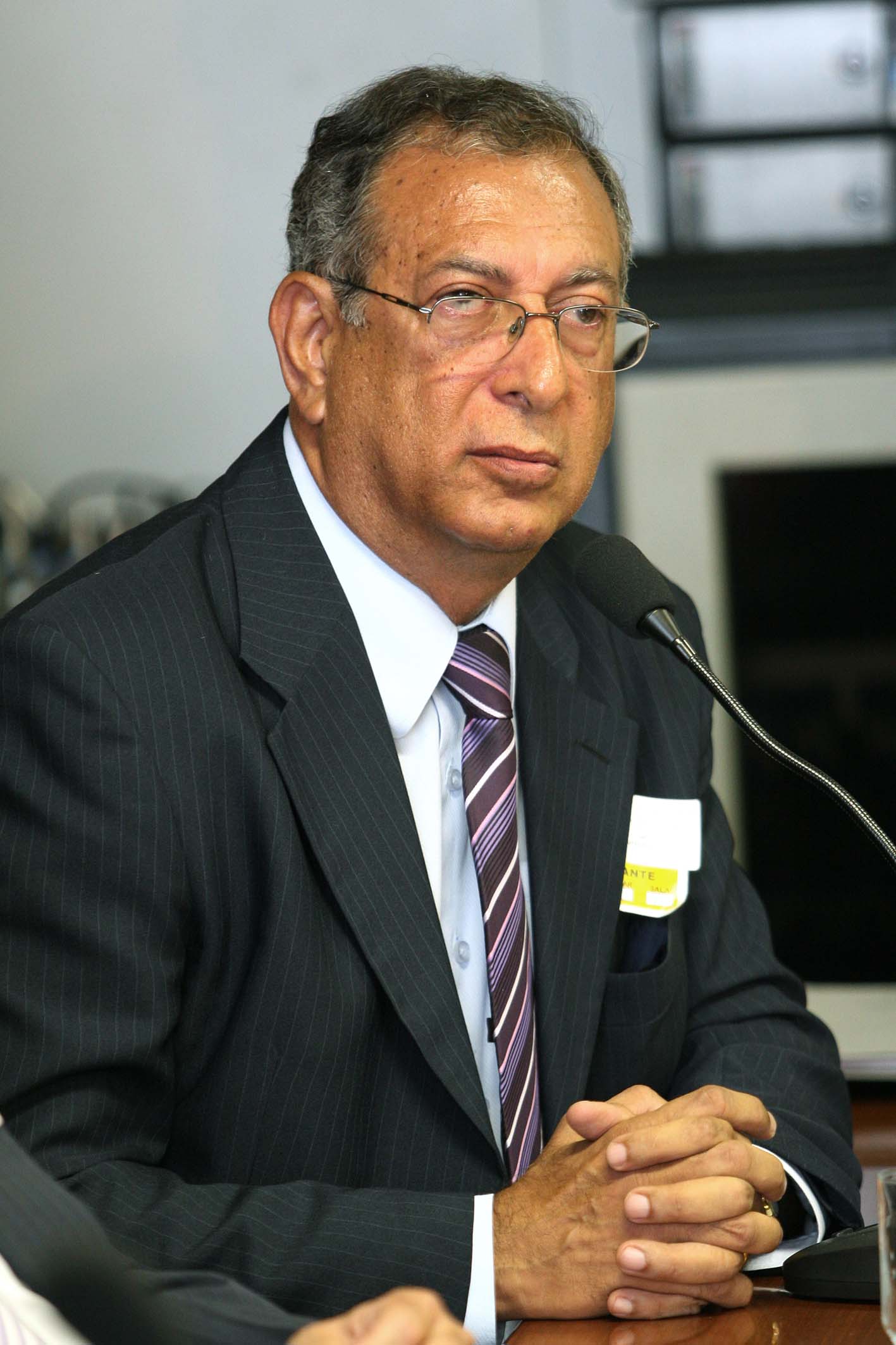 a man with glasses wearing a suit and tie
