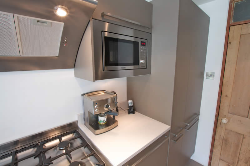 a kitchen has a microwave and a toaster oven on the counter