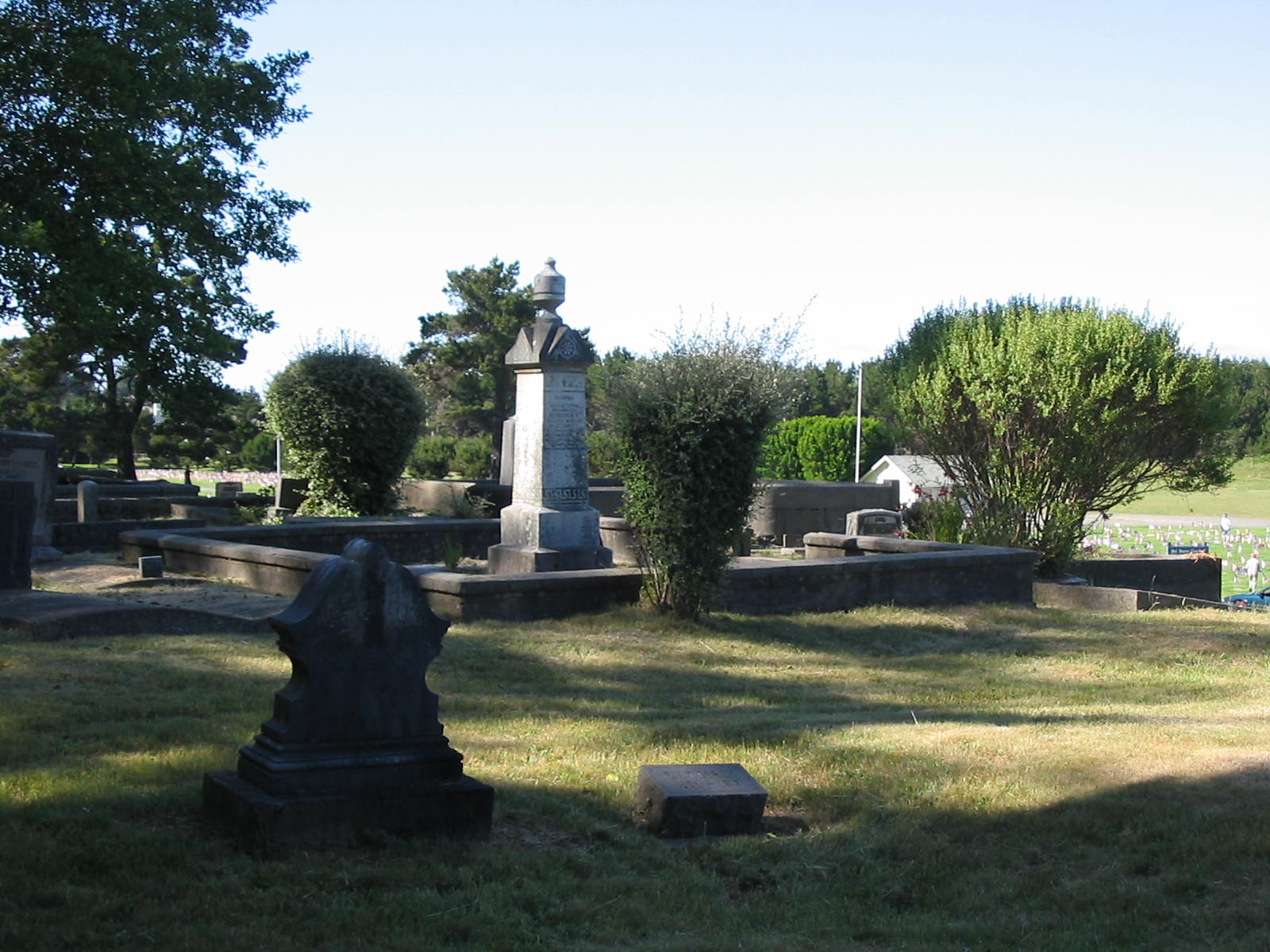 the cemetery has two headstones with green grass