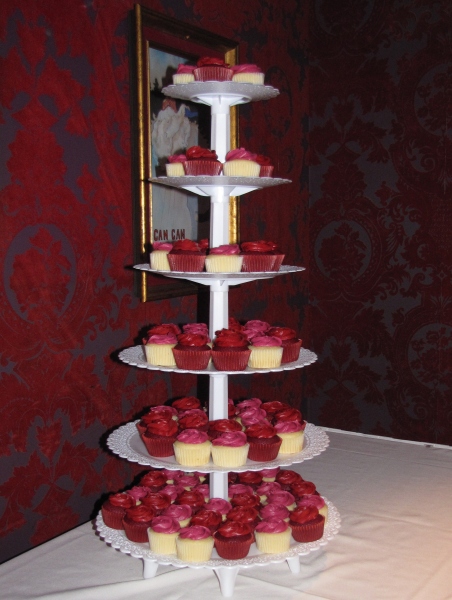 a triple tiered plate with cupcakes sitting on it