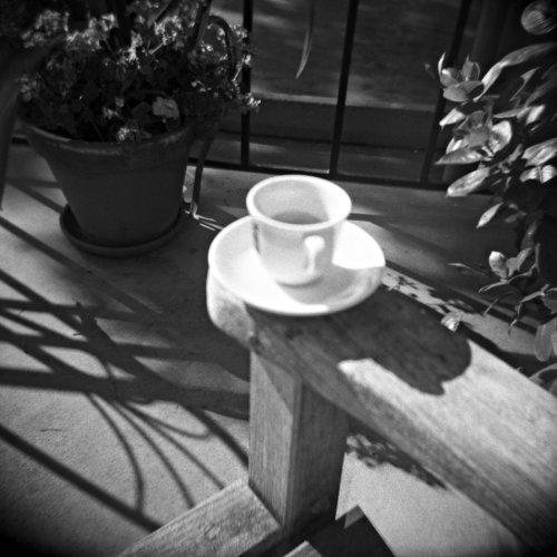 a small cup and saucer are on a table outdoors