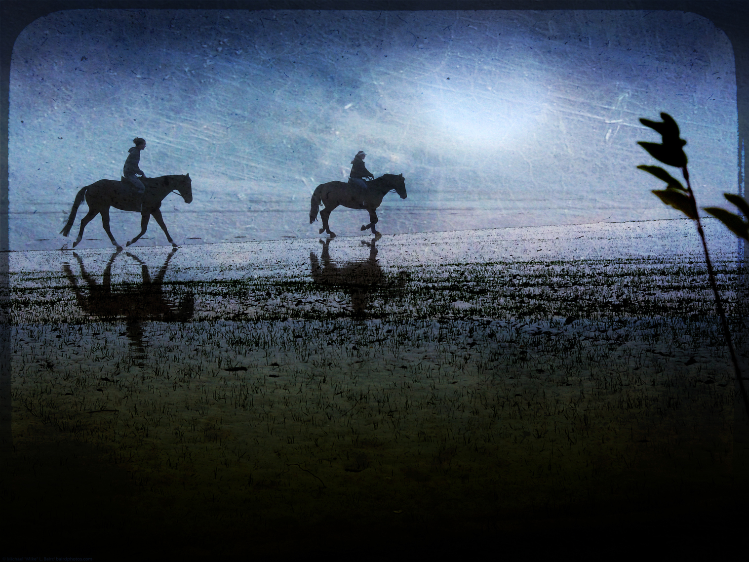 three people riding horses along a sandy beach