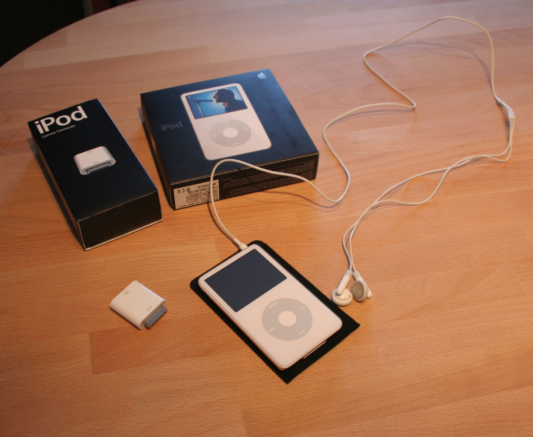 a wooden table with two ipods and an mp3 player