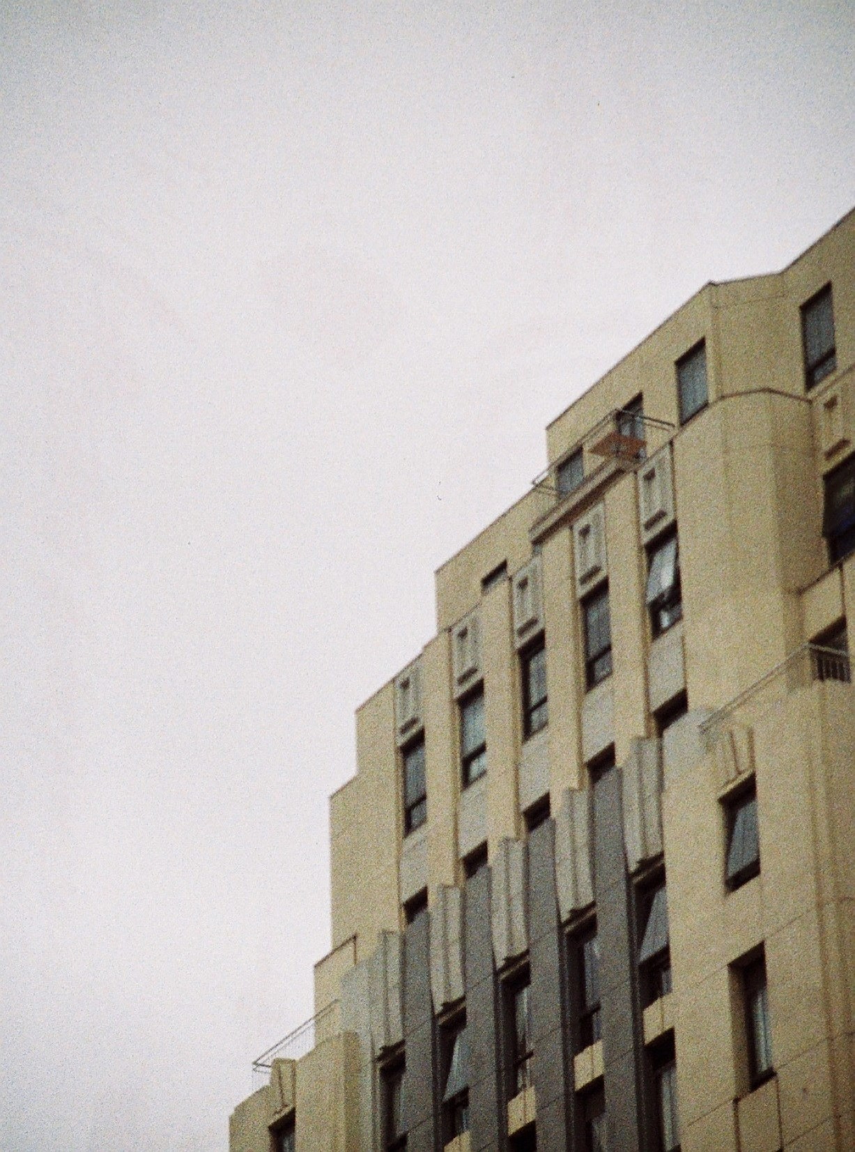 a tall tan building with some windows and curtained around it