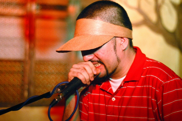 a man is talking on a microphone with a visor on