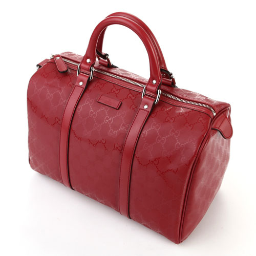 a red handbag with handles and shoulder straps
