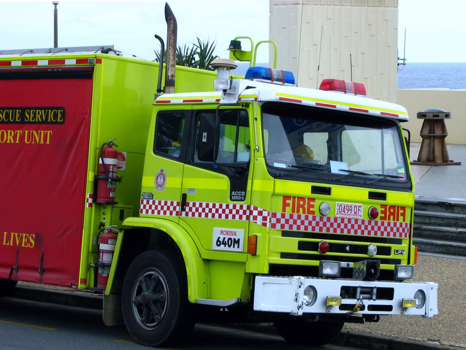 an emergency vehicle parked along the curb on a beach