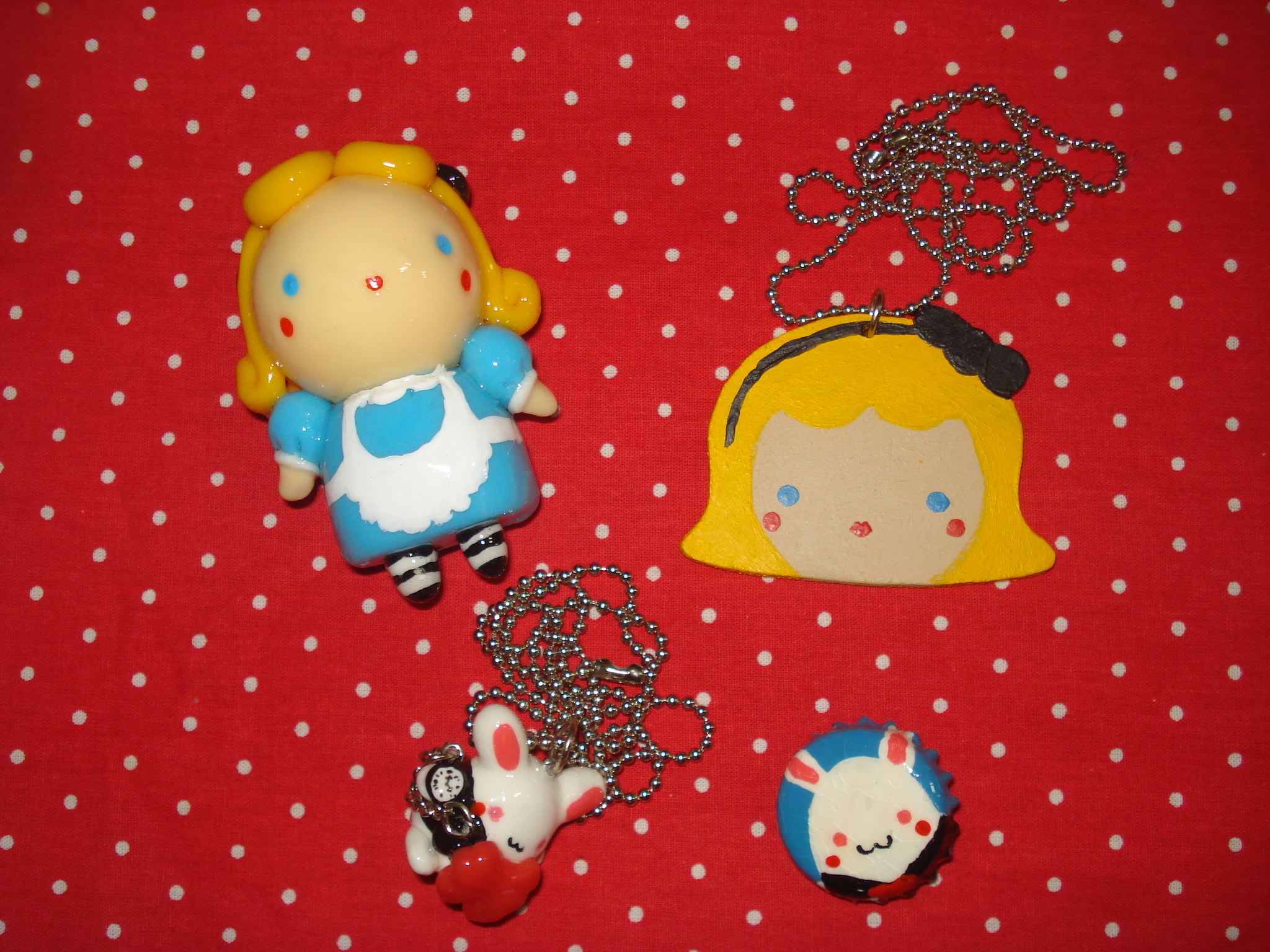 small doll figurines hanging from necklaces on a table