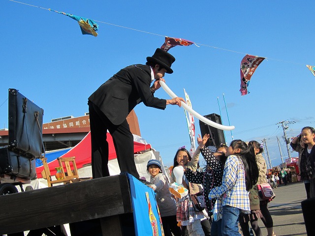 the person with black suit and top hat is playing with kites