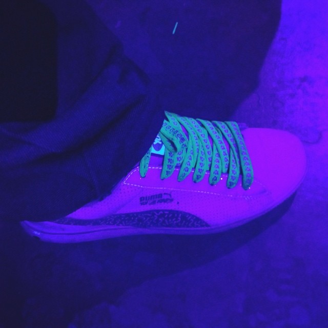 a person is wearing a neon green and purple sneaker